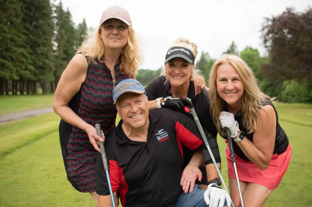 Quatre golfeurs souriants sur un parcours verdoyant