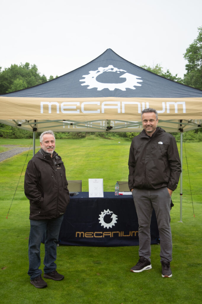 Stand Mecanium avec deux hommes en extérieur