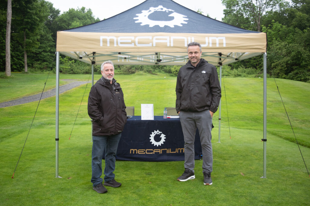Stand Mecanium avec deux hommes en extérieur