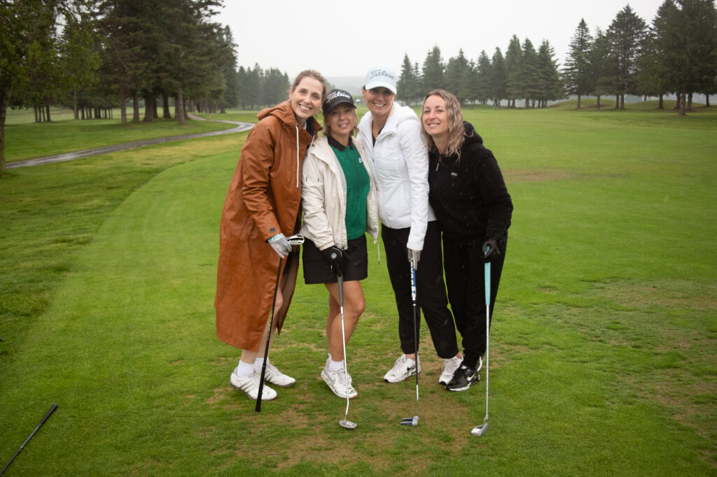Quatre femmes souriantes sur un parcours de golf