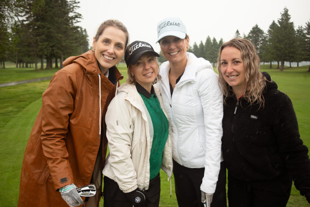 Quatre femmes souriantes sur un parcours de golf