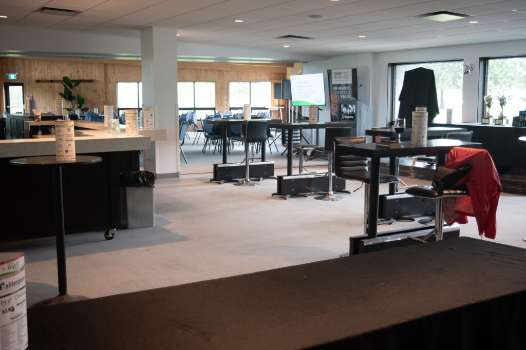 Salle de réception avec tables hautes et écran